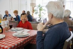 Kinderen eten pannenkoek met ouderen