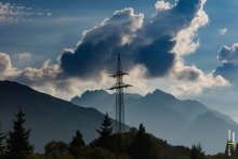 Alpine Silhouette: Power Line Tower Over Forest